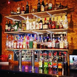 a shelf of liquor bottles on a bar