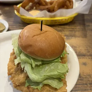 Half a Hoosier tenderloin sandwich with full bun. Other half in the background.