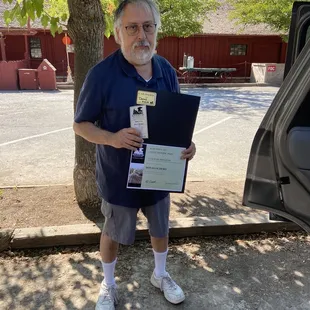 My husband holding  his certificate  of appreciate for selecting the cab ride. He was so excited to receive this unexpected gift.