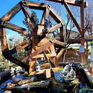 a water wheel in the middle of a garden