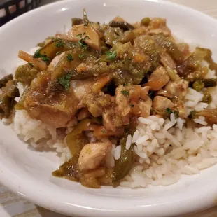 a bowl of rice with chicken and vegetables