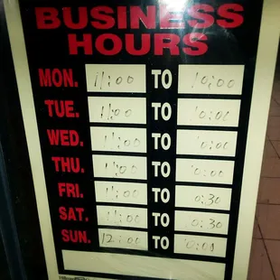 a business hours sign in a window