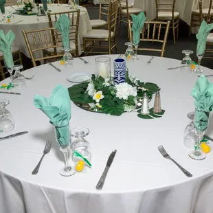 Tiki mugs and pineapple favors provided by the bride but tablecloths, napkins, utensils, greenery all from the venue.