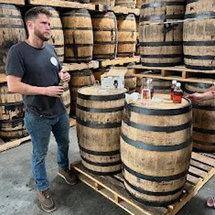 two men standing in front of barrels