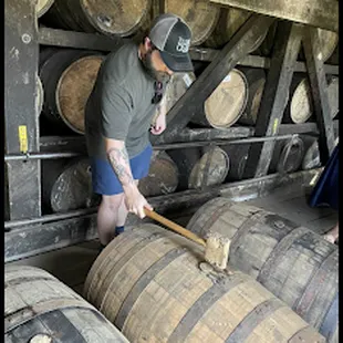 a man with a wooden stick in a barrel