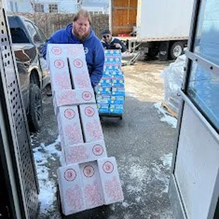 a man carrying a cart full of boxes