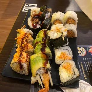 a variety of sushi on a black plate