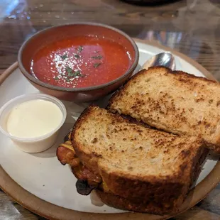 Grilled cheese with bacon sandwich and tomato soup with cream