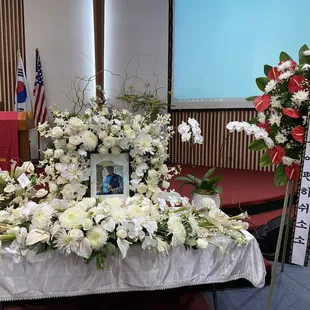 Memorial service spray and flowers around the picture.