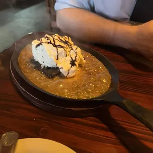 Brownie with ice cream on a hot skillet