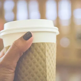 photo of hand holding a to go cup of coffee