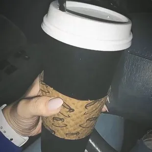 a hand holding a coffee cup