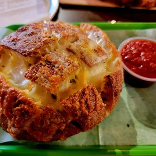 a cheesy bread with a side of ketchup