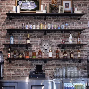 a brick wall with shelves of liquor