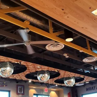 Disco balls on the ceiling. Sign that asks, &quot;What Are Ya&apos; Chicken?&quot;