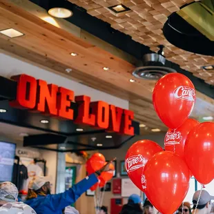 a one love store with red and white balloons