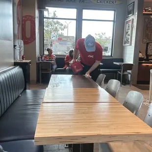 a man in a red shirt sitting at a table in a restaurant