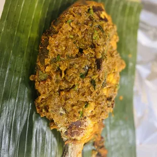 a fried fish on a banana leaf