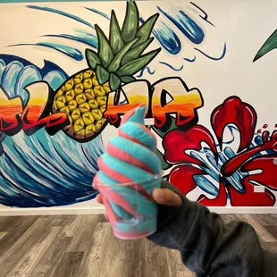 a person holding a pineapple ice cream cone