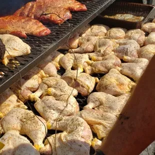 a man cooking chicken on a grill