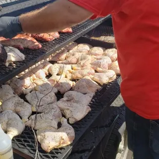 a man cooking chicken on a grill