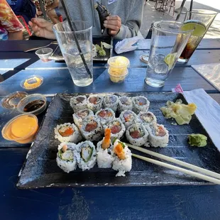 a plate of sushi and chopsticks on a table