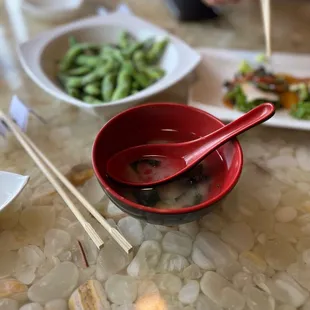 a bowl of soup and chopsticks