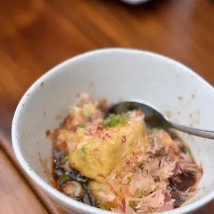 a bowl of food on a wooden table