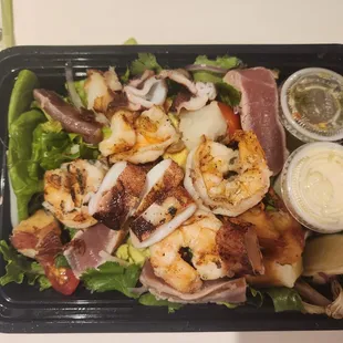 a salad with shrimp, lettuce, and other ingredients