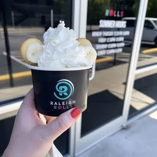 a hand holding a cup of ice cream