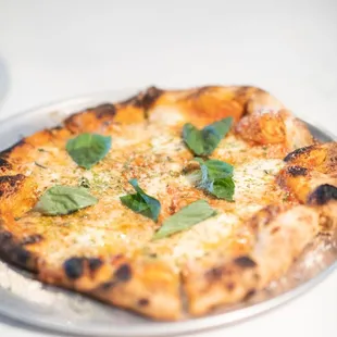 a pizza with cheese and basil on it