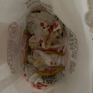 4 burgers jammed into the bottom of a sack with four orders of "large" fries on top.