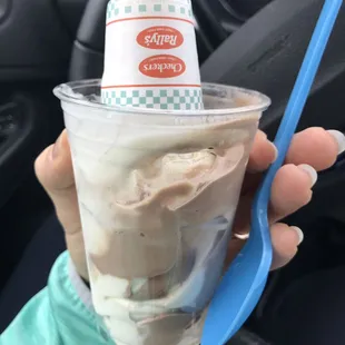 a hand holding a cup of ice cream