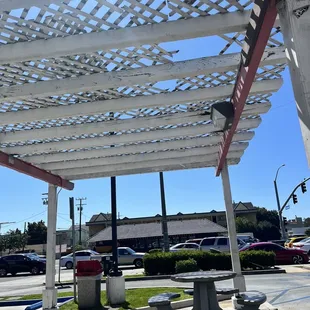 a picnic table under a pergolated roof