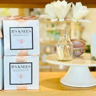 a vase of flowers, a candle, and a box of tissues on a table