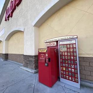 a red vending machine and a red phone booth