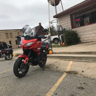 a red motorcycle parked in front of a water tower