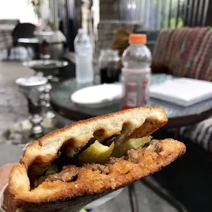 a hand holding a sandwich