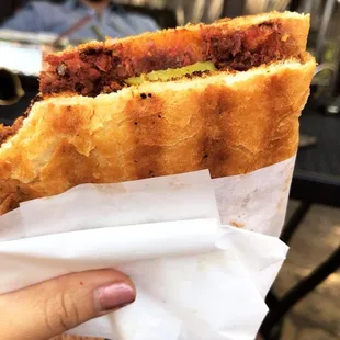 a person holding a sandwich