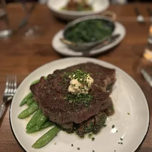 ribeye special with a side of spinach and kale in the background. Looks better than it is