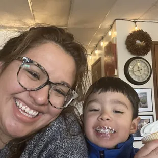 a woman and a boy eating a cupcake