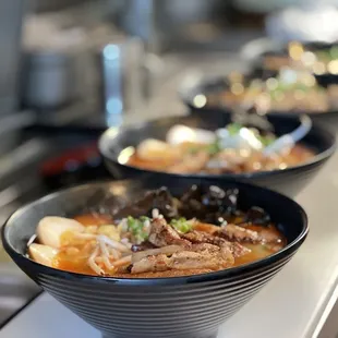 a row of ramen bowls on a counter