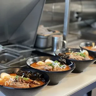 a row of ramen bowls on a counter