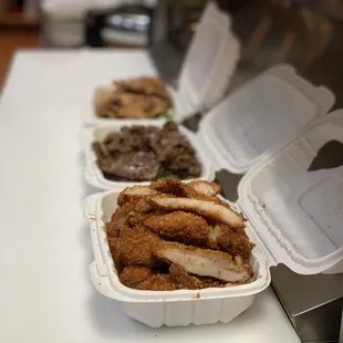 three takeout containers of ramen