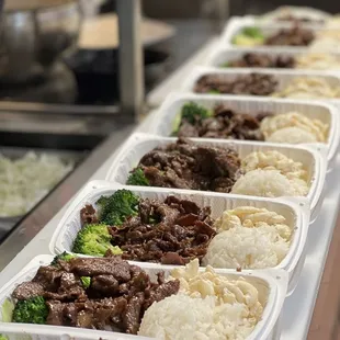 a row of plastic containers filled with food