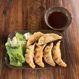 a plate of dumplings and a salad