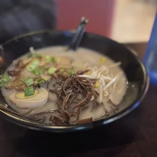 a bowl of ramen with noodles and scallions