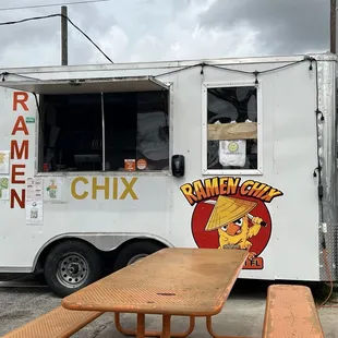 a food truck parked next to a picnic table