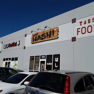 cars parked in front of ramen hashi