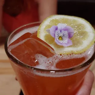 a person holding a glass of lemonade